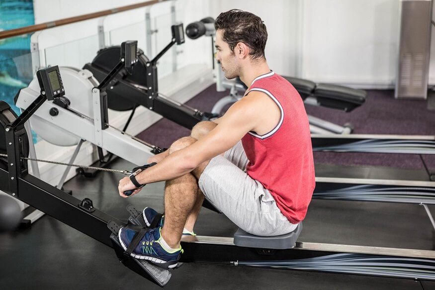 Un homme faisant des cardio sur rameur