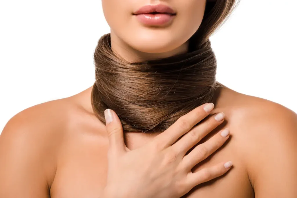 Une femme avec les cheveux autour du cou qui se tient la poitrine