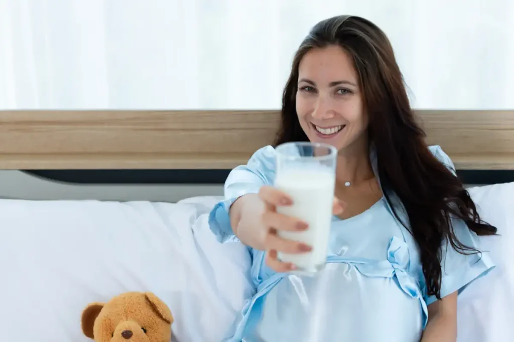 Une femme qui tend un verre de lait