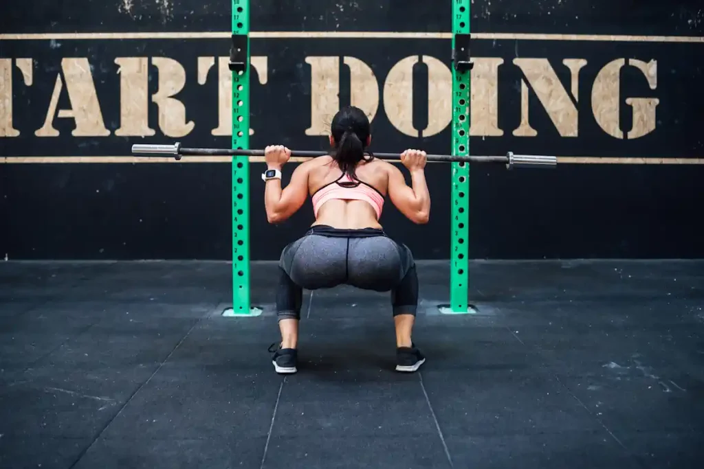 Une femme qui fait su squat avec du poids
