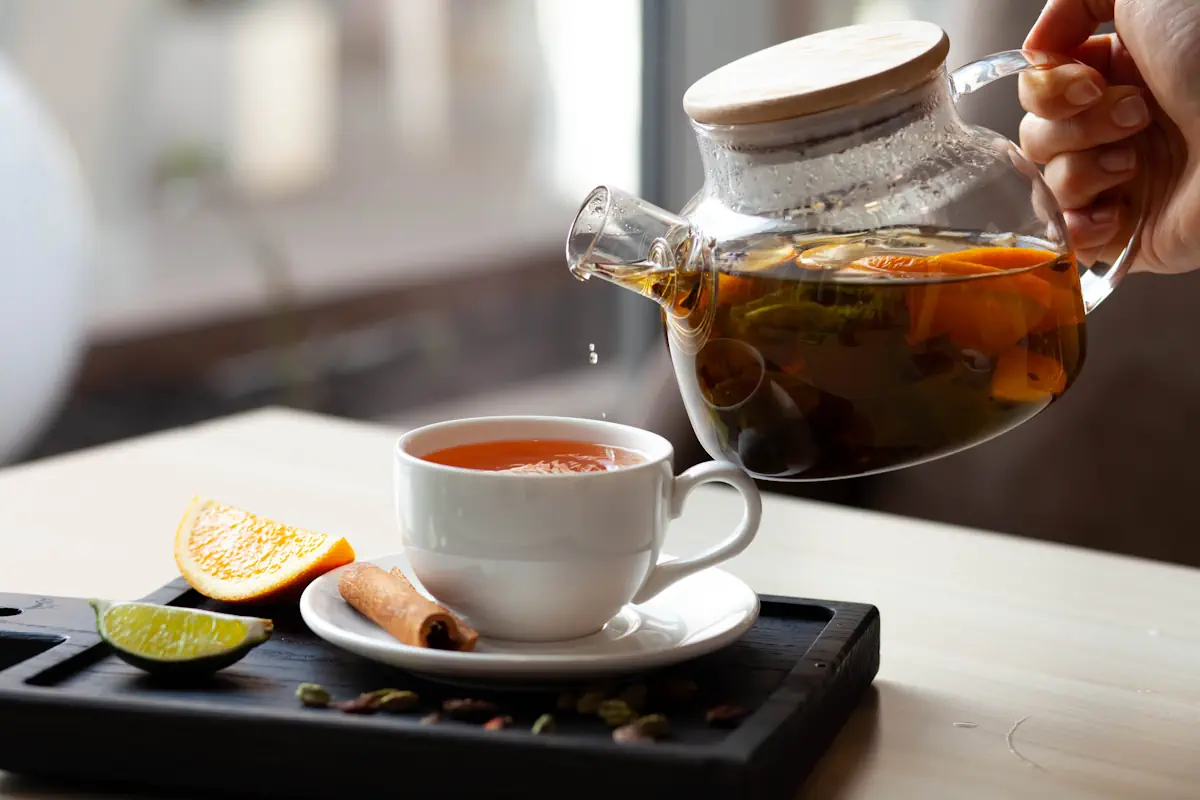 Une personne qui verse une infusion dans une tasse
