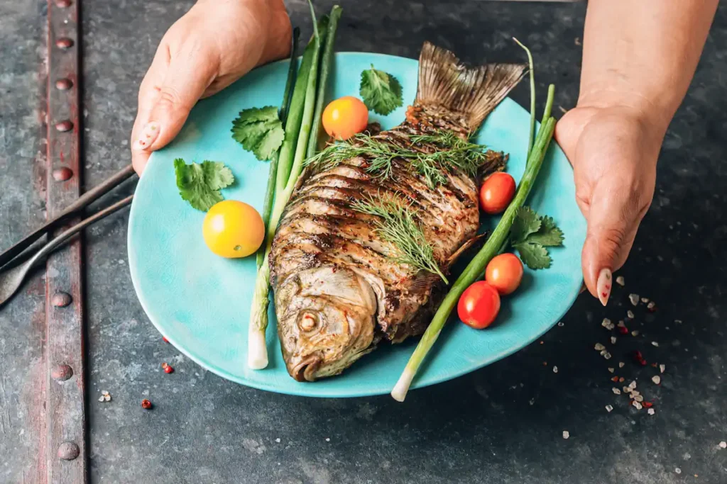 Une assiette de poisson tenue par une personne