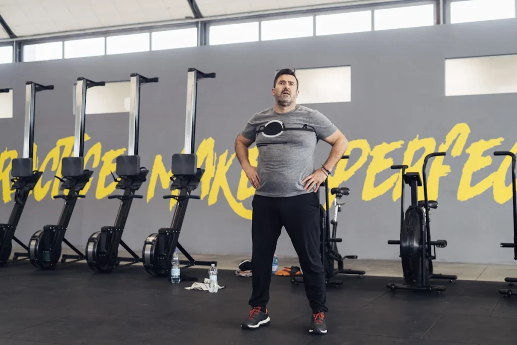 Un homme qui se tient debout devant des appareils de sport