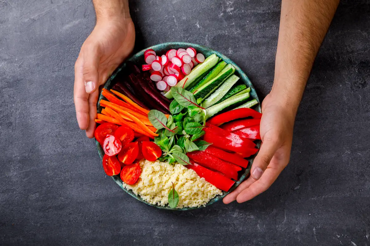 Une personne qui tient une assiette de légumes colorés
