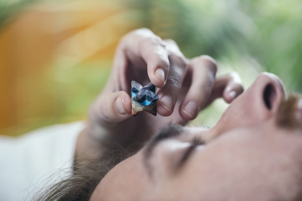 Une personne qui pose un cristal sur le front d'une autre