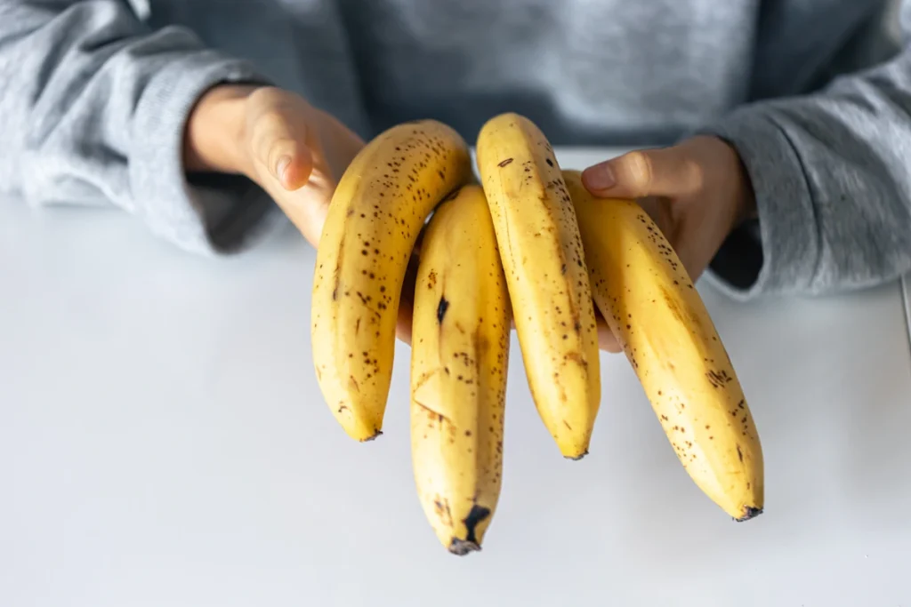 Une personne qui tient des bananes dans sa main