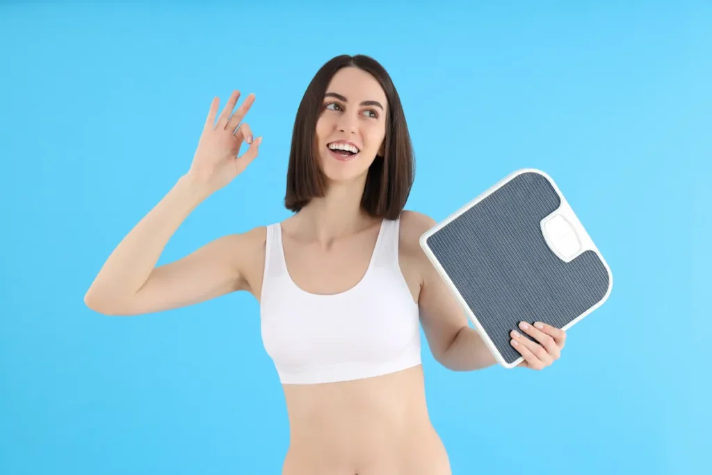 Une femme qui tient une balance dans sa main en souriant