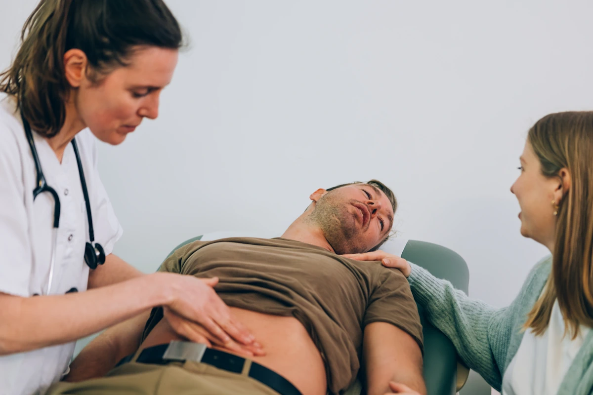 Un homme accompagné d'une femme qui se fait consulter par un médecin