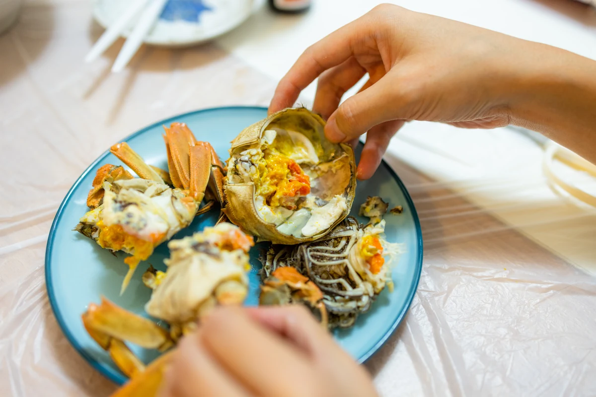 Une personne qui mange une assiette de crustacées