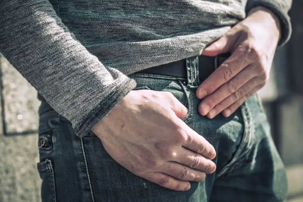 Un homme debout qui se tient l'entrejambe