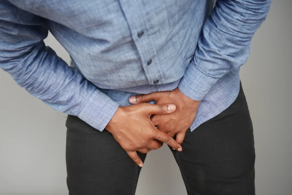 Un homme qui se tient l'entrejambe