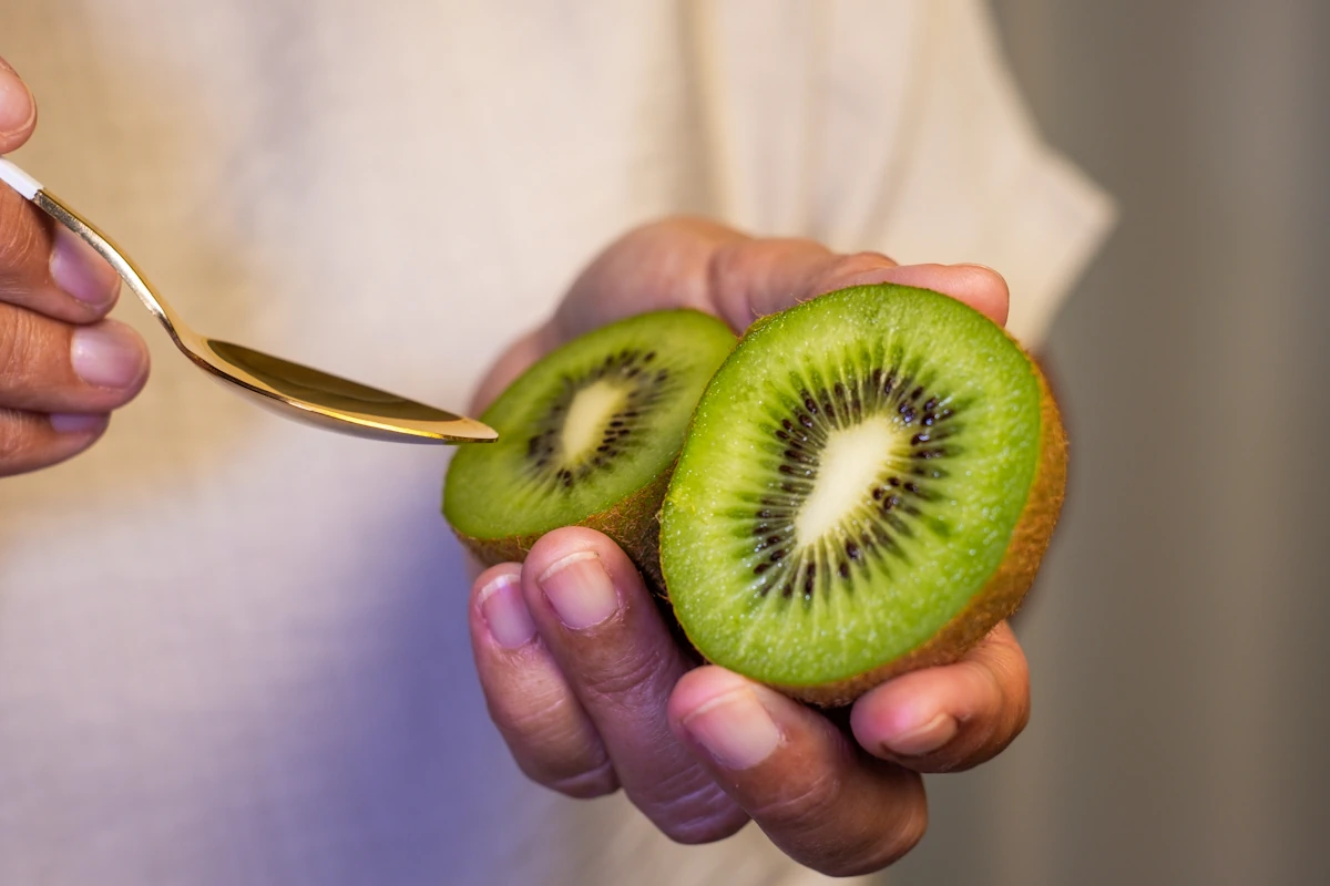 Une personne qui mange un kiwi