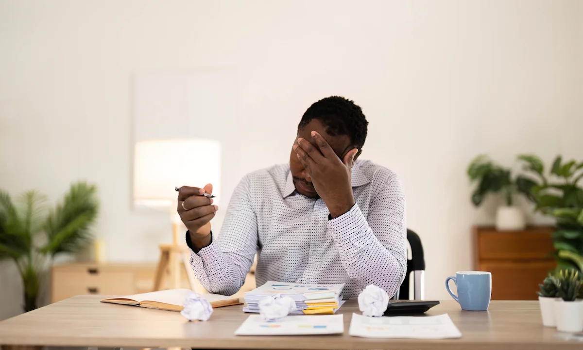 Un homme adulte à son bureau qui a du mal à se concentrer
