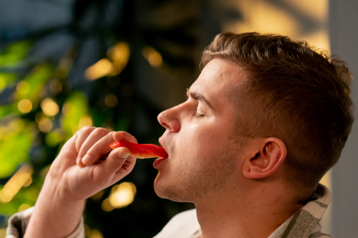 Un homme qui mange du piment rouge