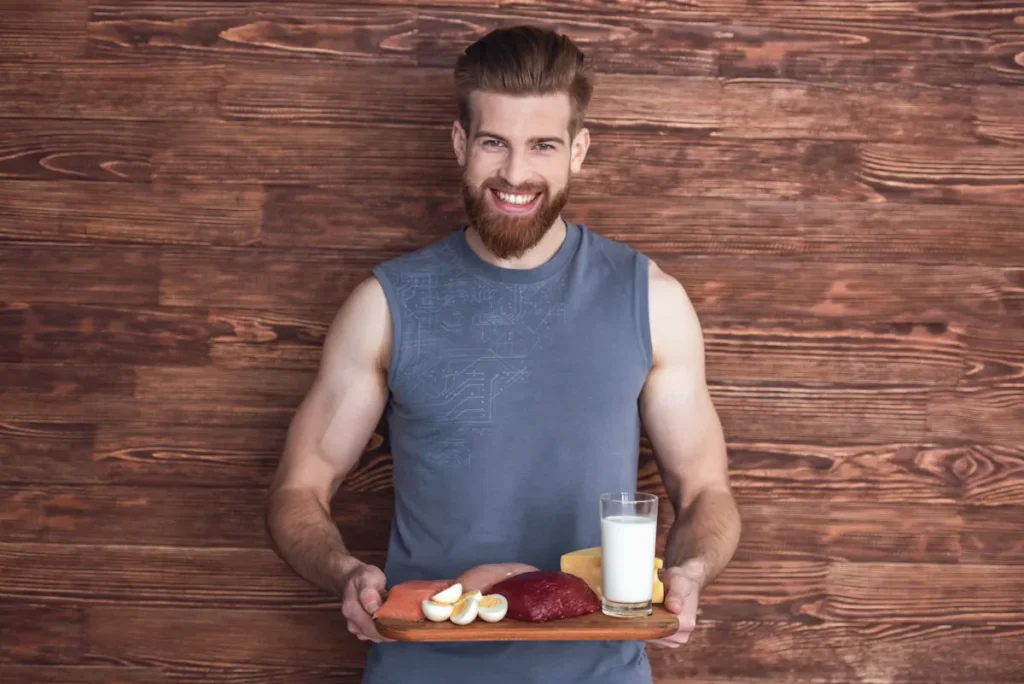 Un homme en période de sèche sportive qui tient un plateau avec du lait et de la viande