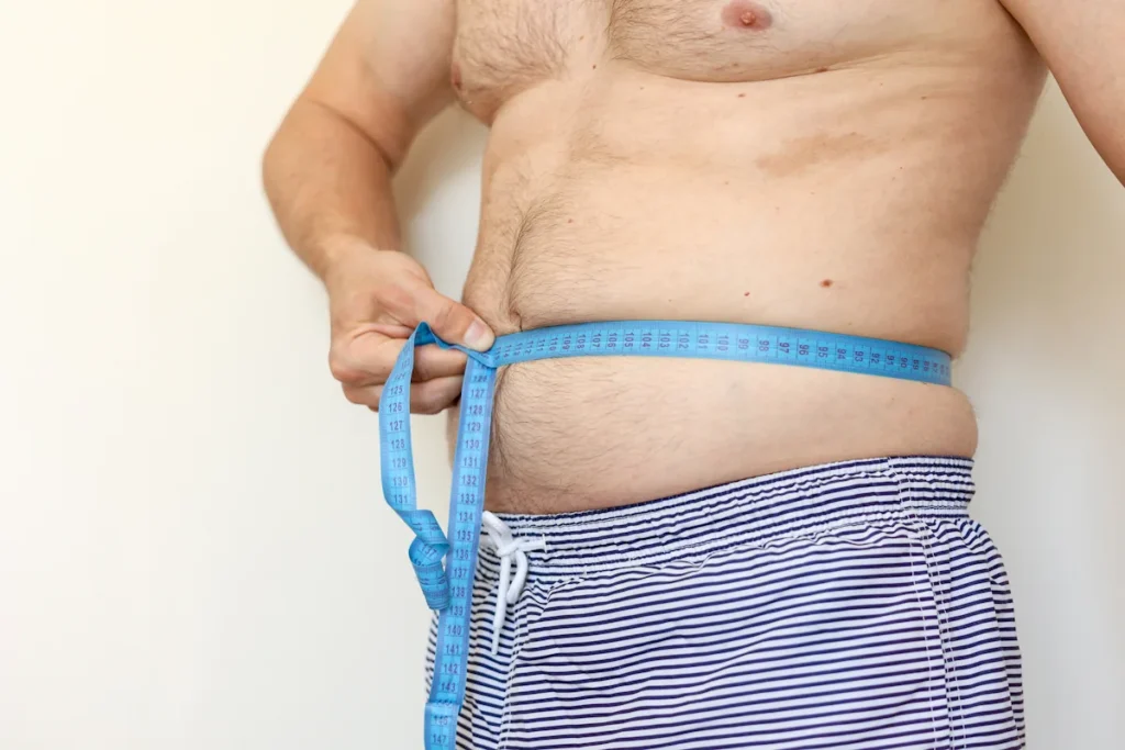 Un homme qui mesure sa tour de taille