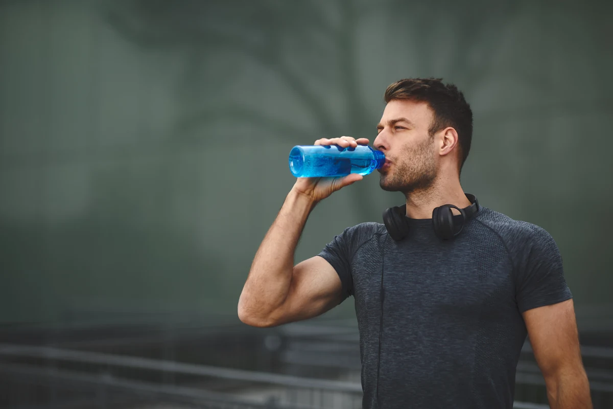 Un sportif qui boit de l'eau riche en électrolytes