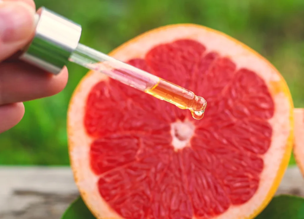 Une personne qui tient une pipette d'extrait de graines de pamplemousse