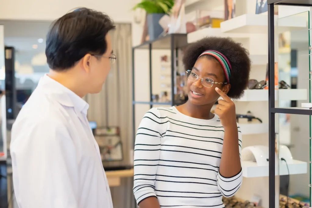 Une jeune femme qui discute de ses lunettes avec un opticien