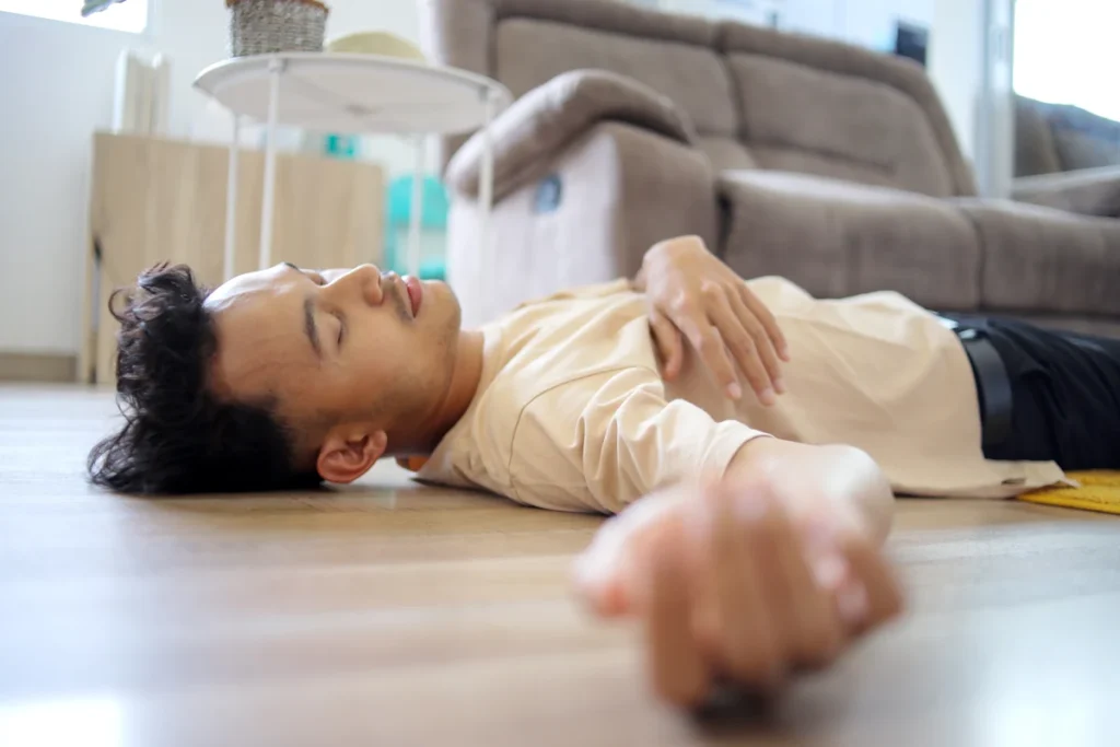 Une personne allongé sur le dos sur le sol après une crise d'épilepsie